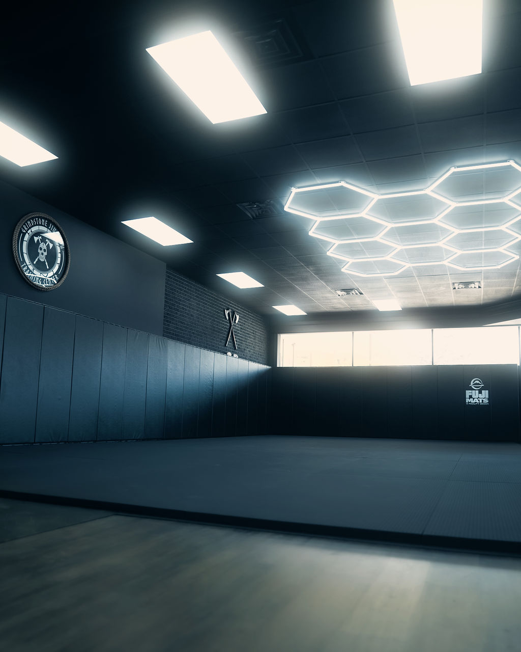 Grindstone Jiu Jitsu training mats beneath the academy emblem