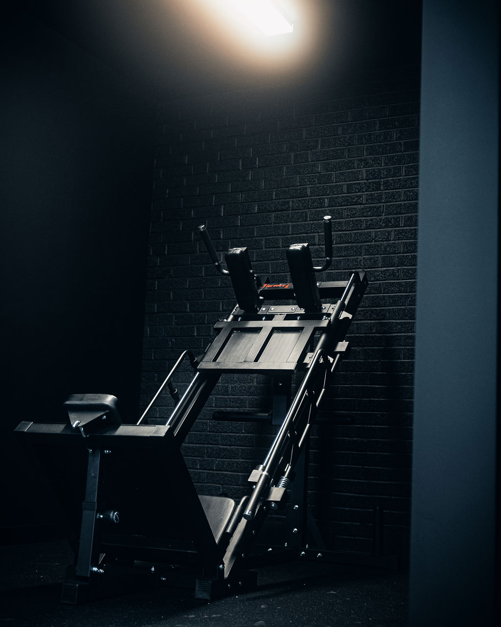 Strength machine in a black brick equipment room